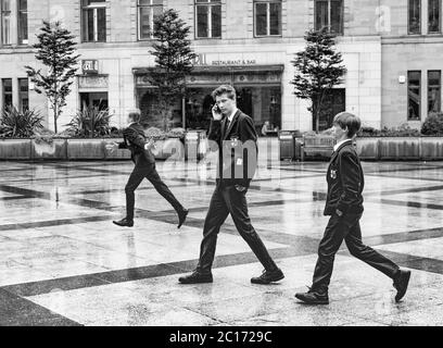 Monochromes (schwarz-weiß) Bild von drei Schülern der Dundee High School auf dem City Square, Dundee nach der Abschlussfeier der Schule in der Caird Hall. Stockfoto