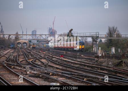 South West Züge der Klasse 455 innerer S-Bahn vorbei Clapham Junction, Süd-London mit den Turmdrehkranen auf der Londoner Skyline dahinter. Stockfoto