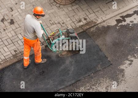 Asphalt Pflaster Arbeiter manuelle Maschine Ansicht von oben Stockfoto