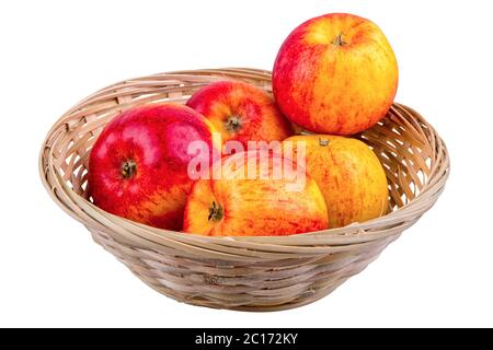 Weidenkorb mit Äpfeln isoliert auf weißem Hintergrund Stockfoto