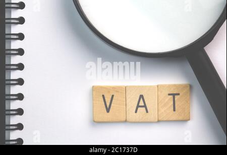 MwSt-Text (Value Added Tax) auf Scrabble Holzstücke isoliert auf weißem Notizblock Stockfoto