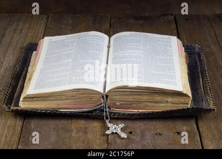 Alte Bibel auf rustikalen Holztisch mit Kreuz Buch mark Stockfoto