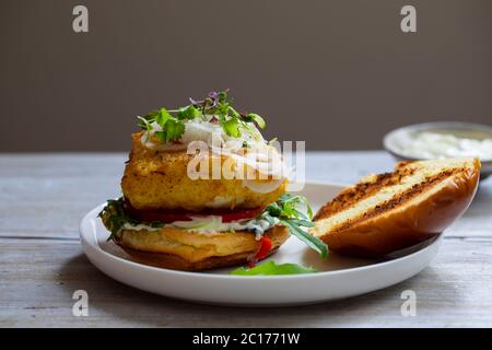 Kurkuma Fisch Burger in Brioche Brötchen Stockfoto