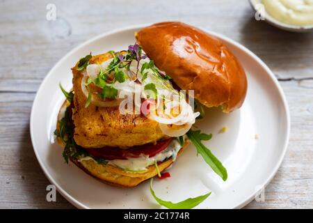 Kurkuma Fisch Burger in Brioche Brötchen Stockfoto
