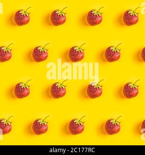 Strawberry Nahtloses Muster, Erdbeeren auf gelbem Hintergrund, Draufsicht, kreative minimalistische flache Lay, Sommer Muster Stockfoto