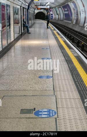 LONDON, ENGLAND - 8. JUNI 2020: Anmeldung der London Underground Platform zur Beratung der sozialen Distanzierung des Weltraums 3 Stockfoto