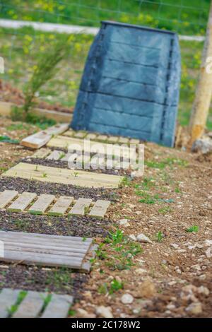 Holzsteg aus Plattenholz mit schwarzem Kunststoffbehälter im Stadtgarten Stockfoto