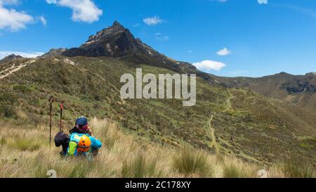 Quito, Pichincha / Ecuador - 8. September 2019: Junge Touristin, die mitten im Grasland in der Nähe des Vulkans Rucu Pichincha sitzt Stockfoto