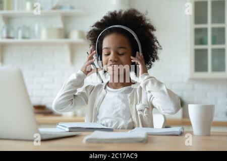 Afrikanisches Mädchen trägt Kopfhörer hören Audio Lektion lernt Schulfach Stockfoto