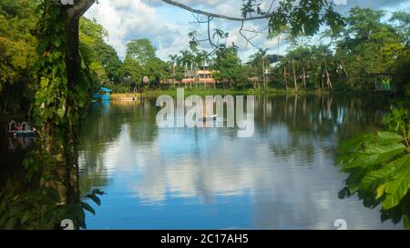 Nueva Loja, Sucumbios / Ecuador - Dezember 21 2019: Paar rudert an einem bewölkten Nachmittag am Stadtrand in der Lagune von Julio Marin mit dem Boot. Stockfoto