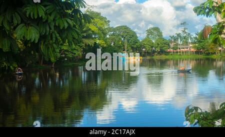 Nueva Loja, Sucumbios / Ecuador - Dezember 21 2019: Paar rudert an einem bewölkten Nachmittag am Stadtrand in der Lagune von Julio Marin mit dem Boot. Stockfoto