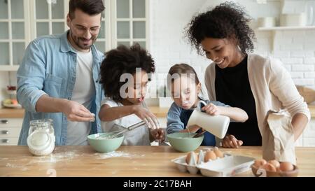 Voll multi ethnischen Familie Kochen Pfannkuchen zusammen in der modernen Küche Stockfoto