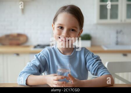 Kopfschuss Porträt kleines Mädchen hält Glas stilles Wasser Stockfoto