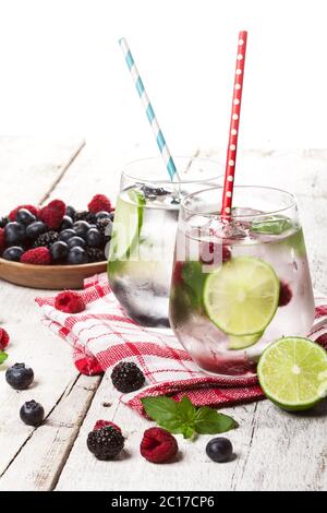 Sommerliche kalte Getränke mit Himbeeren, Brombeeren und Blaubeeren auf weißem Hintergrund Stockfoto