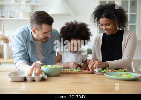 Liebevolle multiethnische Eltern lehren biracial kleine Tochter Kochen in der Küche Stockfoto