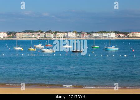 Ciboure, Frankreich - 26. September 2016: Ciboure Strand mit wenigen Touristen und Saint jean de Luz Bucht mit luxuriösen Booten im Hintergrund Stockfoto