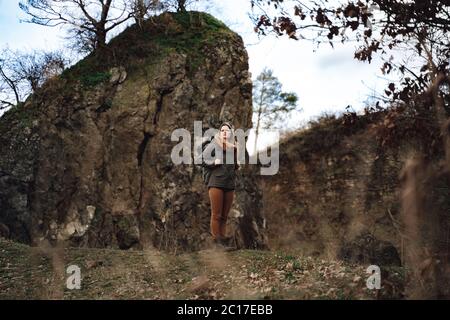 Junge Frau Wanderer im Herbst von Hügeln umgeben Stockfoto