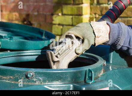 Nahaufnahme eines Mannes, der einen gebundenem Öltank mit Heizöl (Kerosin) in einem Haus im ländlichen England, Großbritannien, füllt Stockfoto