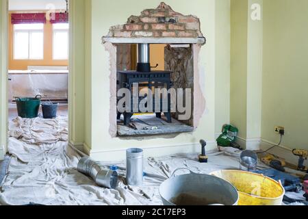 Installation eines doppelseitigen Holzofen während eines britischen Bauprojekt Stockfoto