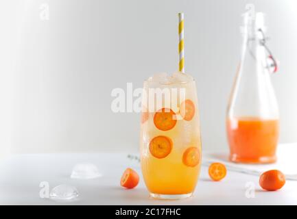 Sommer Detox Drink mit Kumquat, Mandarine und Eiswürfel auf weißem Hintergrund.Bild in horizontaler Ausrichtung mit Platz für Text, Nahaufnahme. Stockfoto