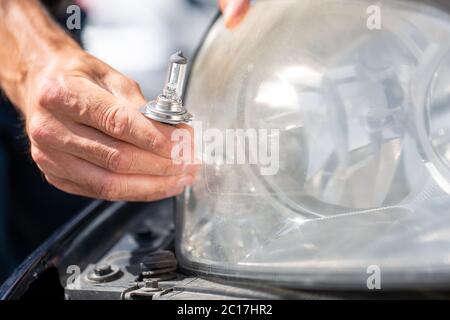 Junger Mann Hände ändern Auto Glühbirne oder Blitzlampe der Scheinwerfer oder Scheinwerfer, Reparatur Auto Konzept Stockfoto