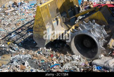 Nahaufnahme der Planierraupe arbeiten auf der riesigen Deponie oder Müllhalde Haufen, Verschmutzung Konzept Stockfoto