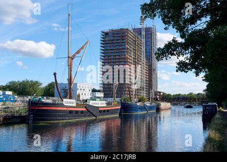 Der River Lea in Tottenham Hale, North London, Großbritannien, mit Flussbargen und der neuen Hale Wharf Wohnsiedlung im Bau Stockfoto