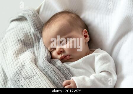 Ein Nahaufnahme Porträt eines kleinen Mädchens, das in einer Wiege oder Krippe schläft. Drei Monate altes Mädchen schläft süß. Hochwertige Fotos Stockfoto