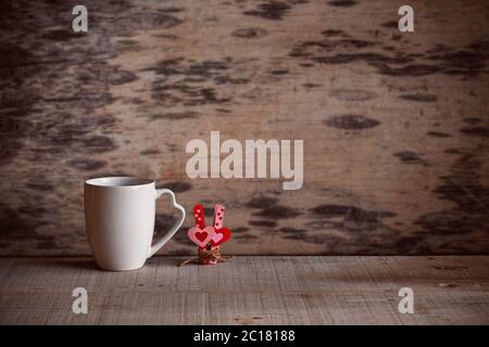 Tasse und Herz mit Liebe auf Holzboden. Stockfoto