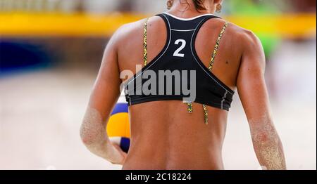 Eine weibliche Beach Volleyball-Spieler ist immer bereit, den Ball zu dienen Stockfoto