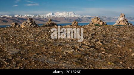 Rituelle cairns im Heiligtum in Tashi Dor Halbinsel, Nam Lake, mit der Nyenchen Tangula als Kulisse, Tibet Stockfoto