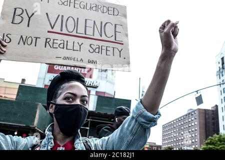 New York, New York, USA. Juni 2020. Eine Frau hält ein Protestschild vor Adam Clayton Powell Jr. State Office Building for a Black Lives Matters Bewegung marsch und Kundgebung im Gefolge des Todes von George Floyd in der Harlem Nachbarschaft von New York, New York. Die Proteste um die Nation gehen weiter und weitere Proteste werden mit dem Tod eines Schwarzen durch die Hände eines Polizisten in Atlanta, Georgia, erwartet. Kredit: Brian Branch Price/ZUMA Wire/Alamy Live Nachrichten Stockfoto