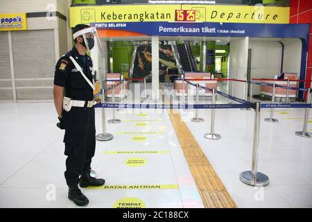 (6/14/2020) Offizier mit Gesichtsmaske, der den Eingang der Passagiere am Bahnhof Gambir im Zentrum von Jakarta bewacht. PT Kereta API Indonesia (Persero) nahm den Betrieb von regelmäßigen Fernzügen auf, die nach der Einführung des COVID-19-Präventionsprotokolls ab Juni 12 wieder in Betrieb genommen wurden. Früher wurden regelmäßige Fernzüge durch außerordentliche Eisenbahnen ersetzt, da die Beförderung von Personen eingeschränkt und die Bewegung eingeschränkt war. (Foto von Kuncoro Widyo Rumpoko/Pacific Press/Sipa USA) Stockfoto