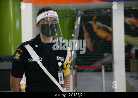 (6/14/2020) Offizier mit Gesichtsmaske, der den Eingang der Passagiere am Bahnhof Gambir im Zentrum von Jakarta bewacht. PT Kereta API Indonesia (Persero) nahm den Betrieb von regelmäßigen Fernzügen auf, die nach der Einführung des COVID-19-Präventionsprotokolls ab Juni 12 wieder in Betrieb genommen wurden. Früher wurden regelmäßige Fernzüge durch außerordentliche Eisenbahnen ersetzt, da die Beförderung von Personen eingeschränkt und die Bewegung eingeschränkt war. (Foto von Kuncoro Widyo Rumpoko/Pacific Press/Sipa USA) Stockfoto