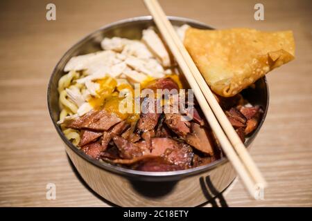 Nahaufnahme von indonesischem Essen, Fleischnudeln, Bakmi, serviert auf einer Schüssel mit Essstäbchen. Stockfoto