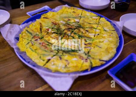 Koreanische herzhafte Meeresfrüchte und Schalotten gebratenen Pfannkuchen auf einem großen Teller. Stockfoto