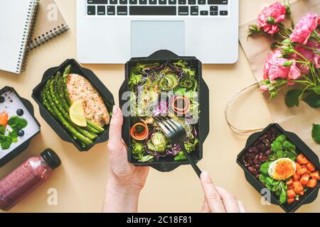 Weibliche Hände halten die Lebensmittellieferbox, die von zu Hause aus zu Mittag auf der Arbeit geht. Stockfoto