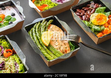 Ready gesunde Lebensmittel Menü Mahlzeit Lieferung Take Away Boxen auf schwarzem Hintergrund. Stockfoto