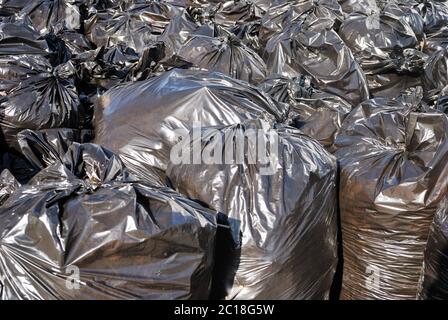 Stapel von schwarzen Mülltüten mit Tonnen Müll, horizontal Stockfoto