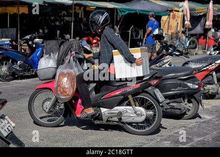 Überlast Motorrad. Frau trägt ihre Einkaufslast auf einem Motorrad. Thailand Südostasien Stockfoto