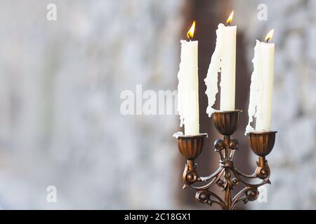 Kerzenleuchter mit drei Kerzen auf grauem Hintergrund Stockfoto