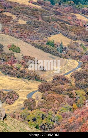 Kurvenreiche Straße durch ein malerisches Tal im Herbst Stockfoto
