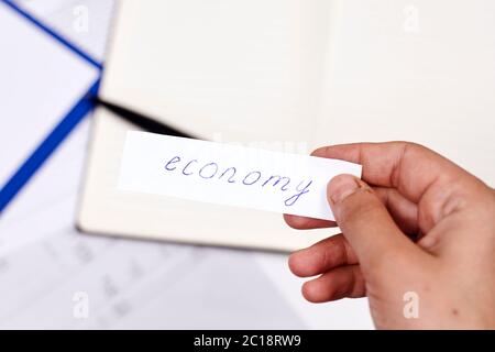 Mann, der Papier mit Wort zerreißt - Wirtschaft. Konzepte von Wirtschaftskrise, Zusammenbruch der Wirtschaft, Zusammenbruch der Wirtschaft. Die Weltwirtschaft nach der Coronavirus-Krise Stockfoto