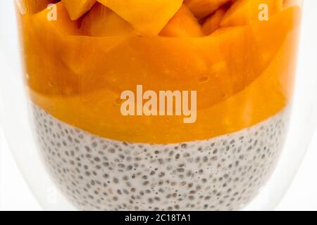 Chia-Samen-Pudding-Smoothie mit Mango-Nahaufnahme in einem Glas auf weißem Hintergrund Stockfoto