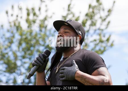 Travis Ross spricht vor einem marsch zur Unterstützung der Black Lives Matter Bewegung im High Point Viertel von Seattle am Sonntag, dem 14. Juni 2020, mit Hunderten von Unterstützern. Ross ist einer der vier Organisatoren des marsches, die alle in der High Point Gemeinschaft leben. Stockfoto