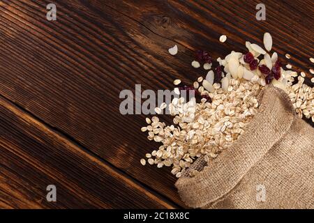 Haferflocken Flocken, Preiselbeeren und Mandeln in sackleinen Tasche Stockfoto