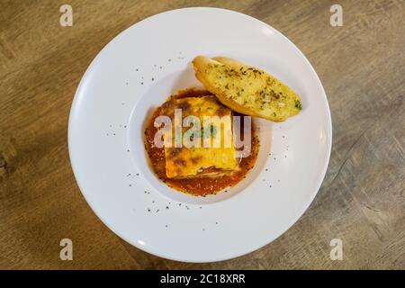 Leckere Servierform traditioneller italienischer Lasagne mit würzigem Rindfleisch auf Tomatenbasis und geschmolzenem Mozzarella-Käse zwischen den Nudelschichten. Serviert mit s Stockfoto