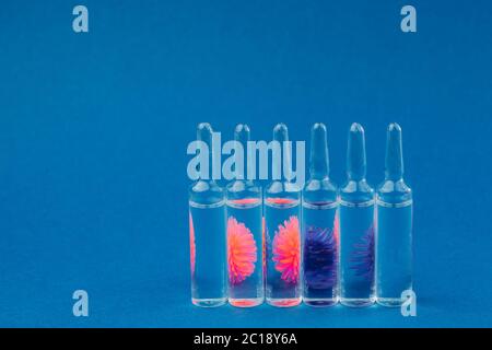 Abstraktes Modell von Coronavirus und Ampulle mit Medizin auf blauem Hintergrund.Konzept des Schutzes gegen ein Pandemievirus. Stockfoto