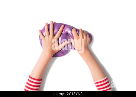 Teenager Hände und lila glänzenden Schleim. Kind Mädchen spielt mit Schleim isoliert auf weiß. Home Lernspiele Konzept. Draufsicht, flaches Lay-Banner. Stockfoto