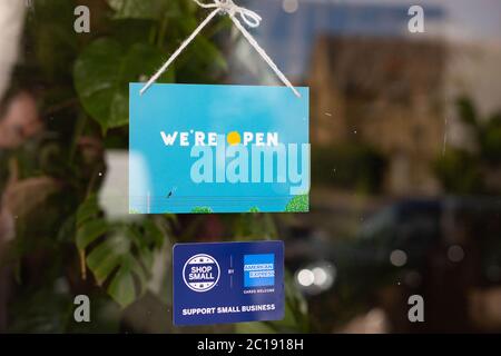 Ein von der Künstlerin Rose Blake entworfenes Schild mit der Aufschrift „WE’RE OPEN“ wurde geschaffen, um die Small-Kampagne des American Express Shops zu feiern und Menschen in unseren Straßen in London willkommen zu heißen. Stockfoto